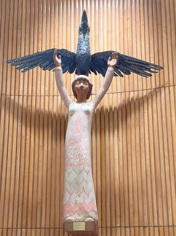 A photo of the sculpture titled "Mankind and Hope" created by Danish sculptor Henrik Starcke, gifted to the United Nations by the Danish Government in 1953. the sculpture is sometimes called the girl and the bird as that is what it looks like, with the girl lifting her arms above her head as the bird flies  with her.